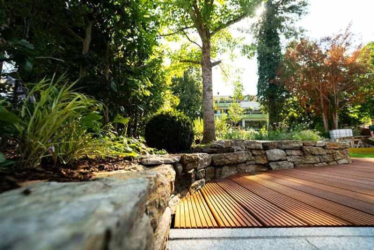 ξύλινο deck κήπου με πέτρινη διαμόρφωση και φυσικό περιβάλλον